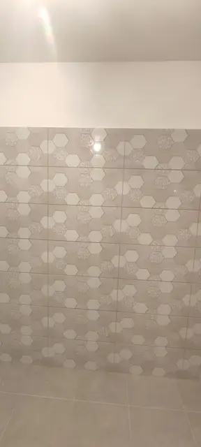 Hatszögletű, barna mozaik falburkolat zuhanyzóban